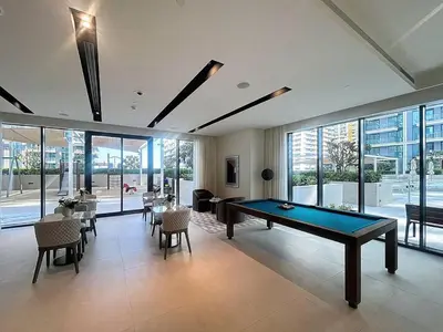 a large room with a pool table and chairs at Vacationer l Modern 1 Bed l Private Beach l Pool, Gym Access in Dubai
