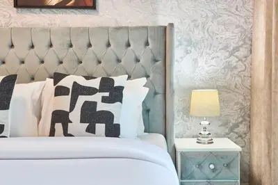 a bedroom with a white bed with a gray headboard at Chic 1BR at The Bay - Business Bay Near Burj Khalifa & Dubai Mall in Dubai