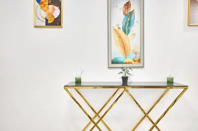 a console table in a room with two pictures on the wall at Chic 1BR at The Bay - Business Bay Near Burj Khalifa & Dubai Mall in Dubai