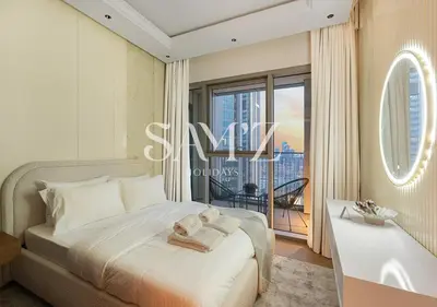 a bedroom with a bed and a large window at Stylish 2BR in Downtown Views - High Floor 2906 in Dubai