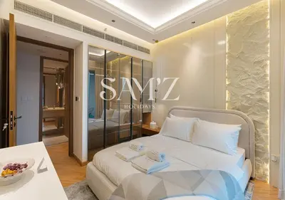 a white bed in a room with asale sign on the wall at Stylish 2BR in Downtown Views - High Floor 2906 in Dubai