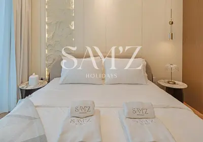 a white bed with two white towels on it at Stylish 2BR in Downtown Views - High Floor 2906 in Dubai