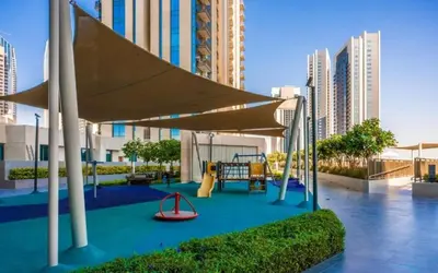 a playground with a slide and a swing at Designer 1BR Dubai Creek Harbour in Dubai
