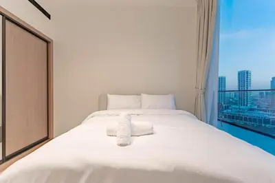 a white bed in a room with a window at HAVN - 2 Bed with Private Pool, JVC in Dubai