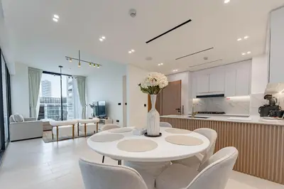 a kitchen and living room with a table and chairs at HAVN - 2 Bed with Private Pool, JVC in Dubai