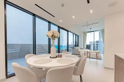 a white dining room with a table and chairs at HAVN - 2 Bed with Private Pool, JVC in Dubai