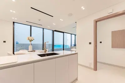 a white kitchen with a view of the ocean at HAVN - 2 Bed with Private Pool, JVC in Dubai