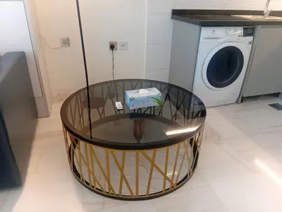 a glass table in front of a washing machine at Studio Hide Away in the Business Bay in Dubai