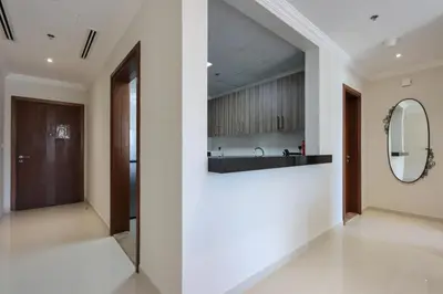 a hallway with white walls and a mirror and a sink at Modern 1BR next to Dubai Mall and Burj Khalifa in Dubai