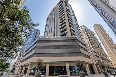 a tall building with trees in front of it at Modern 1BR next to Dubai Mall and Burj Khalifa in Dubai