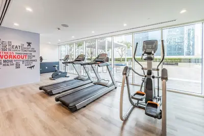 a gym with treadmills and ellipticals in a building at Vibrant City Living, 1Bedroom with Balcony - Vera Tower, Business Bay by Deluxe Holiday Homes in Dubai