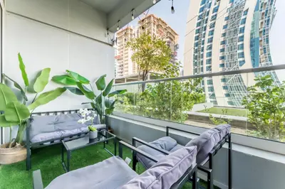 a balcony with chairs and plants and buildings at Vibrant City Living, 1Bedroom with Balcony - Vera Tower, Business Bay by Deluxe Holiday Homes in Dubai