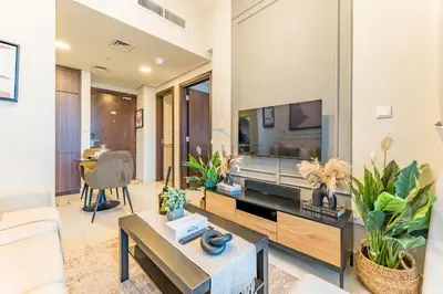 a living room with a couch and a tv at Vibrant City Living, 1Bedroom with Balcony - Vera Tower, Business Bay by Deluxe Holiday Homes in Dubai