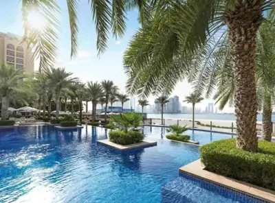 a swimming pool with palm trees in a resort at Fairmont The Palm Luxury Apt 2413 in Dubai
