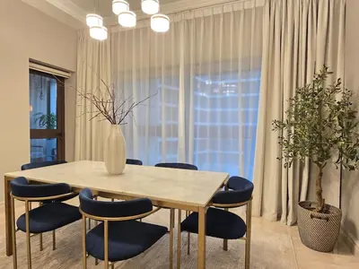 a dining room table with blue chairs and a vase on it at Fairmont The Palm Luxury Apt 2413 in Dubai