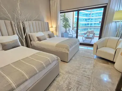 a bedroom with two beds and a couch and a chair at Fairmont The Palm Luxury Apt 2413 in Dubai