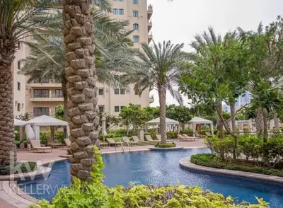 a resort with a swimming pool and palm trees at Fairmont The Palm Luxury Apt 2413 in Dubai