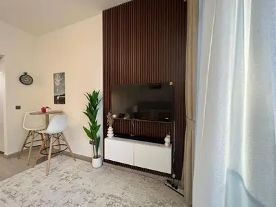 a living room with a large screen tv in a room at Stylish & Luxe Studio - AZIZI 19 Riviera-Great Views in Dubai