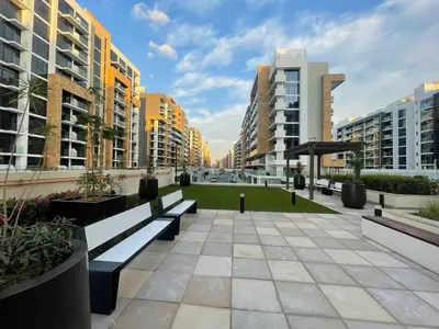 a park with benches in a city with buildings at Stylish & Luxe Studio - AZIZI 19 Riviera-Great Views in Dubai