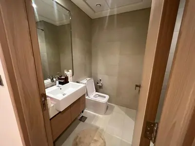 a bathroom with a sink and a toilet and a mirror at Stylish & Luxe Studio - AZIZI 19 Riviera-Great Views in Dubai