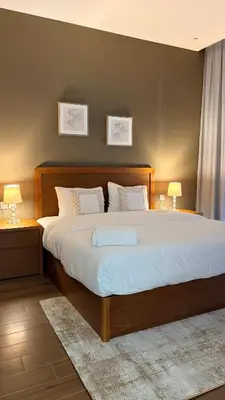 a bedroom with a large bed with two tables and two lamps at Spacious 1BR with Modern Living in Al Furjan-805 in Dubai