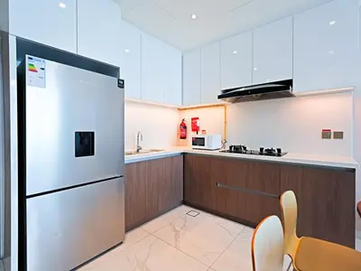 a kitchen with a stainless steel refrigerator and wooden cabinets at Spacious 1BR with Modern Living in Al Furjan-805 in Dubai
