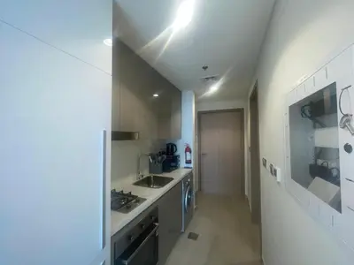a white kitchen with a sink and a stove at Studio in Azizi Riviera, 45 in Dubai
