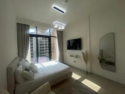 a bedroom with a large white bed and a window at Studio in Azizi Riviera, 45 in Dubai