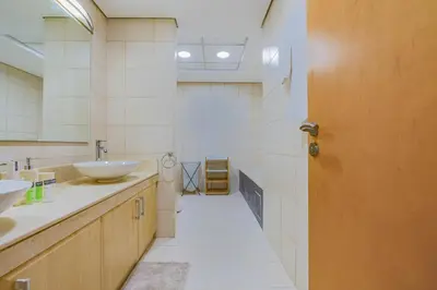 a bathroom with a sink and a mirror and a door at HAVN - Spacious 2 Bed in Al Hallawi, Palm Jumeirah in Dubai