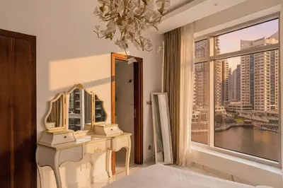 a dressing table in a room with a large window at 1 Bedroom Deluxe Apartment with Marina Views in Dubai