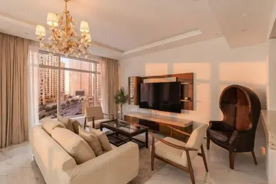 a living room with a couch and a tv at 1 Bedroom Deluxe Apartment with Marina Views in Dubai