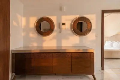 two mirrors above a wooden dresser in a bedroom at 1 Bedroom Deluxe Apartment with Marina Views in Dubai