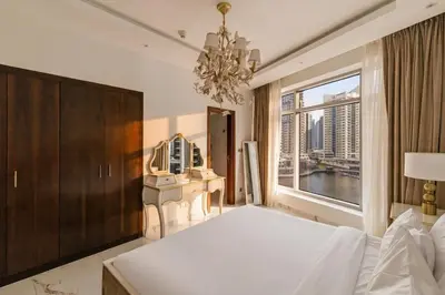 a bedroom with a large bed and a large window at 1 Bedroom Deluxe Apartment with Marina Views in Dubai