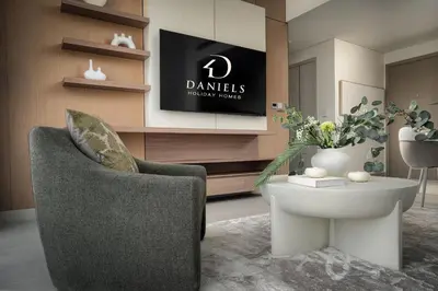 a living room with a chair and a table at Daniels 1BR in Dubai Hills with Park View in Dubai