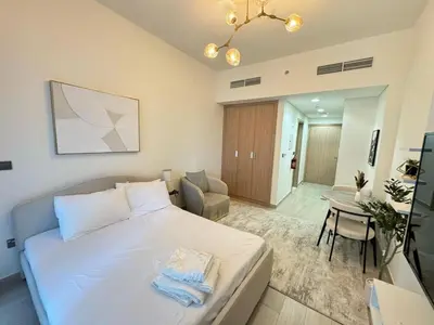 a bedroom with a bed and a table with a chair at Azizi 26 - Unique Studio for Work and Vacation in Dubai