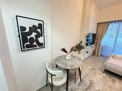 a dining room with a table and chairs in a room at Azizi 26 - Unique Studio for Work and Vacation in Dubai
