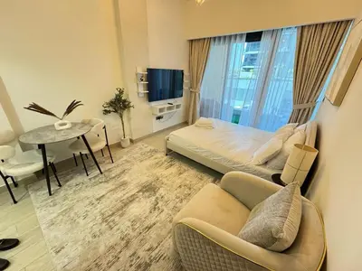 a bedroom with a bed and a table and a couch at Azizi 26 - Unique Studio for Work and Vacation in Dubai