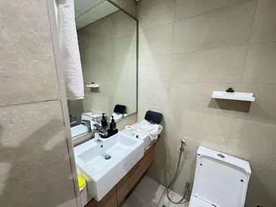 a bathroom with a sink and a toilet and a mirror at Azizi 26 - Unique Studio for Work and Vacation in Dubai