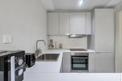 a kitchen with white cabinets and a sink at 2BR Retreat in the Heart of Dubai Marina by EE Holiday Homes in Dubai