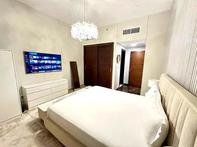 a bedroom with a white bed and a tv at Stylish 1BR in Sparkle Towers Dubai Marina Escape in Dubai