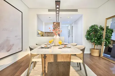 a dining room with a white table and chairs at Royal Amwaj Palm Jumeirah - Luxury 1BR with Pool and Gym in Dubai
