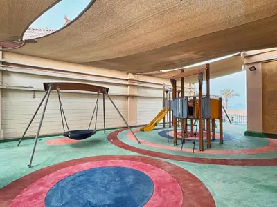 a room with a playground with a swing at Royal Amwaj Palm Jumeirah - Luxury 1BR with Pool and Gym in Dubai