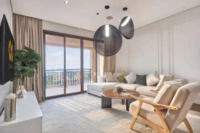 a living room with a couch and a table at Royal Amwaj Palm Jumeirah - Luxury 1BR with Pool and Gym in Dubai