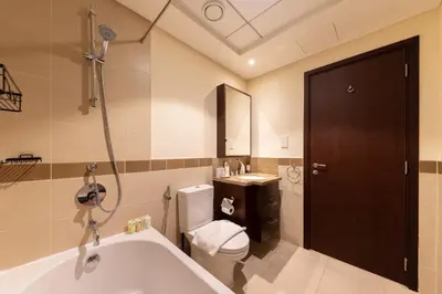 a bathroom with a tub and a toilet and a sink at Elegant 2BR Balcony and Stunning Burj Views in Dubai