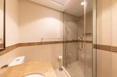 a bathroom with a shower and a toilet and a sink at Elegant 2BR Balcony and Stunning Burj Views in Dubai
