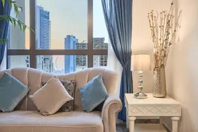 a living room with a couch and a large window at 3-Bedroom Residence in Murjan 5 - Jumeirah Beach with Sea Views in Dubai