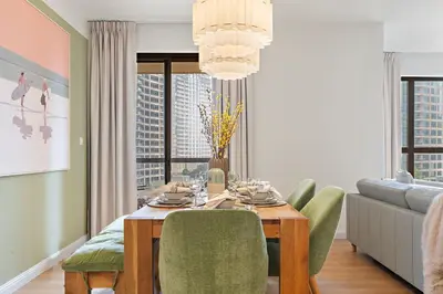 a dining room table with green chairs and a couch at The Smart Concierge - Murjan 5 in Dubai
