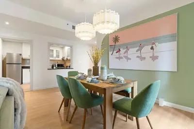 a dining room with a table and green chairs at The Smart Concierge - Murjan 5 in Dubai