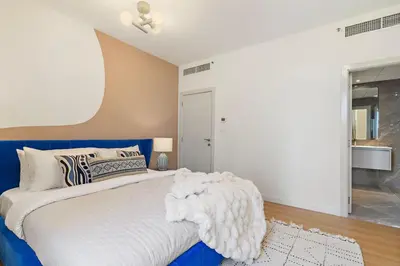 a bedroom with a large bed with a blue headboard at The Smart Concierge - Murjan 5 in Dubai