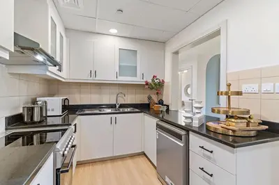 a large kitchen with white cabinets and a sink at The Smart Concierge - Murjan 5 in Dubai